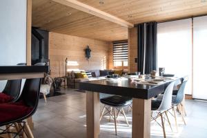 a dining room with a black table and chairs at Chalet 4M Les Carroz et son Spa in Les Carroz d'Araches