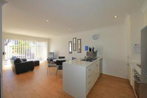 a living room filled with furniture and a kitchen at Alexandra Apartments in Bundaberg
