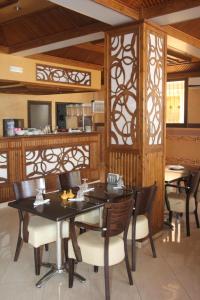 a dining room with tables and chairs and a kitchen at Hôtel Sable d'Or in Tan-Tan