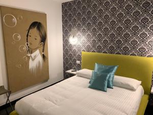1 dormitorio con 1 cama y una pintura de una mujer en Voglia di Vino Locanda, en Alba