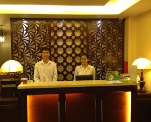 2 persone in piedi a un bancone in una camera d'albergo di Asian Ruby Boutique Hotel Bùi Thị Xuân ad Ho Chi Minh