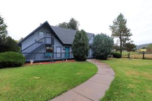 a white house with a porch and a grass yard at Sweetgrass Inn Bed & Breakfast in Rapid City