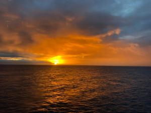 um pôr-do-sol sobre o oceano num navio em Apartamentos Mesa em Valle Gran Rey