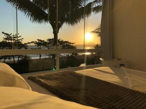 um quarto com uma cama e vista para o oceano em Pousada Caravelas em Guarapari mais 37 fotografias