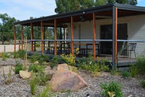 a pavilion with a table and chairs in a garden at Yarrawonga Riverlands Tourist Park in Yarrawonga