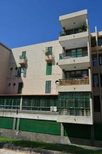 een appartementencomplex met een groen hek ervoor bij Family Beach Apartment in Playa de las Americas