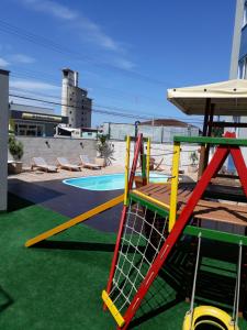 a playground with a chair and a swing at Apartamento Central in Penha