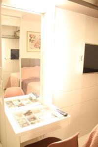 a room with a desk with a mirror and a bed at Apartamento Emaús in Parnamirim
