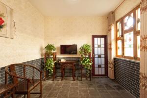 a hallway with a table and a tv on a wall at Pingyao Jiaxin Guesthouse in Pingyao