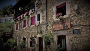 an old stone building with flowers on the windows at Posada Rural Bistruey in Potes