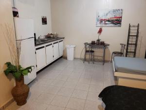 uma cozinha com um frigorífico branco e uma mesa em Jardin del Mar Guesthouse em Hatillo