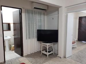 a living room with a flat screen tv on a wall at Jardin del Mar Guesthouse in Hatillo