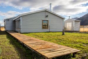 a house with a wooden boardwalk in front of it at Hostal El Puestero in Puerto Natales +15 photos