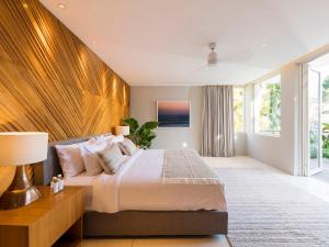 a bedroom with a large bed with a wooden headboard at Noku Beach House by Elite Havens in Seminyak