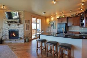 een keuken met een bar met krukken en een open haard bij Bighorn Mountain 19B Condo in Estes Park