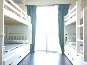 ein Schlafzimmer mit Etagenbetten und einem Fenster in der Unterkunft Yenn's Marina Inn Zamami Condominium in Zamami