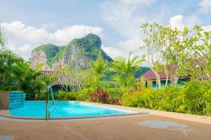 a swimming pool with a mountain in the background at Baannai Lake View Resort in Ao Nang Beach