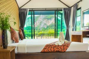 a bedroom with a bed with a large window at Baannai Lake View Resort in Ao Nang Beach +60 photos