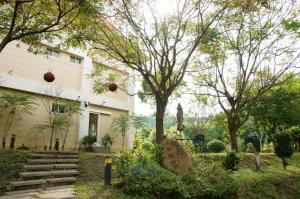 a house with trees and stairs in front of it at Shuang Liou B&B in Mingjian