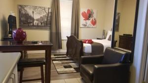 a hotel room with a bed and a desk and chairs at Studio Cozy #12 by Amazing Property Rentals in Gatineau