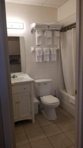 a bathroom with a toilet and a sink and a tub at Studio Cozy #12 by Amazing Property Rentals in Gatineau
