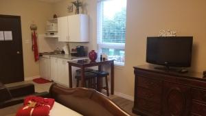 a living room with a television and a kitchen at Studio Cozy #12 by Amazing Property Rentals in Gatineau