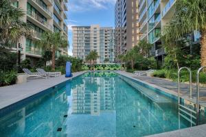 una piscina en un edificio de apartamentos con palmeras en Minimalist & Warming APT - Close to CBD and Valley, en Brisbane