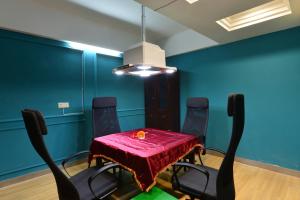 jadalnia ze stołem i krzesłami oraz niebieskimi ścianami w obiekcie Jihao Selected Hotel w mieście Ningbo