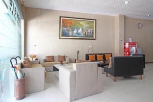 a waiting room with couches and a painting on the wall at RedDoorz near UNS Solo in Solo