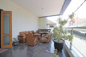 an empty room with chairs and tables and plants at RedDoorz near UNS Solo in Solo