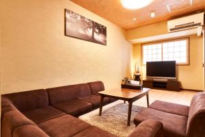a living room with a couch and a tv at Miyazakiya Plus in Kyoto
