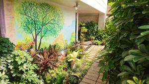 einen Garten mit einem Gemälde an der Seite eines Gebäudes in der Unterkunft 高第商旅 Gaudi Hotel in Kaohsiung
