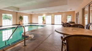a swimming pool with a table and a table and chairs at Best Western Bar Harbour Inn in Massapequa Park