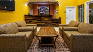 a lobby with two chairs and a table and a tv at Bestway Inn in Kaufman