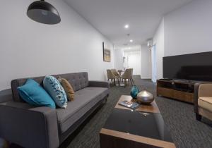 a living room with a couch and a television at The Palms Apartments in Adelaide