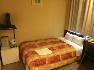 a hotel room with a bed in a room at Green Hotel Shimonoseki in Shimonoseki