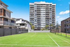 a large building with a tennis court in the middle of it at Majorca Isle Beachside Resort in Maroochydore