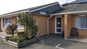 a brick house with a black awning on it at Aalton Motel in Christchurch
