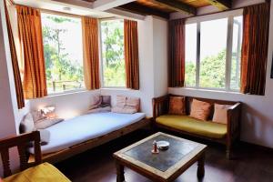 a living room with a couch and two windows at Hotel At The End Of The Universe in Nagarkot