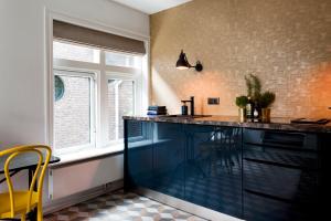 a kitchen with a blue counter and a window at Rooftop 52, City-Apartment in Assen