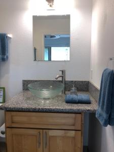 a bathroom with a sink with a glass bowl at Beach Side Studio by Shark's Cove in Haleiwa