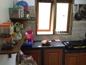 a kitchen with two windows and a counter top at Villa Hembers Surf Camp in Pacitan