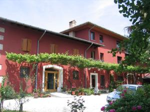 a red house with vines on the side of it at All'Antica Scuderia Del Castello in Maiano