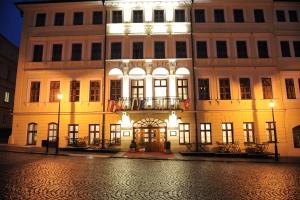a large building with a lit up facade on a street at Hotel Prince de Ligne in Teplice