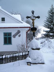 a house with a snow covered pole in front of a fence at Rainmühle in Mariánské Lázně