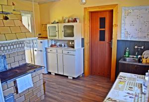 a kitchen with a white refrigerator and a sink at Chata u Borysa in Białowieża