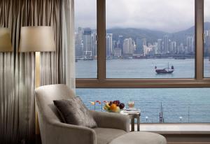 een woonkamer met een raam met uitzicht op het water bij The Royal Garden in Hong Kong