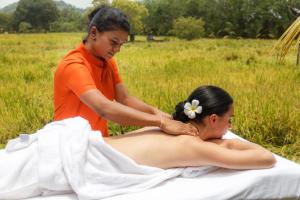 Eine Frau bekommt eine Rückenmassage von einer Frau. in der Unterkunft Sigiriana Resort by Thilanka in Dambulla