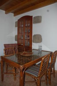 a dining room with a glass table and chairs at Casa Rural Carmita in Vega de San Mateo