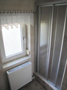 een badkamer met een raam en een radiator bij Ferienwohnung Schade in Hohnstein